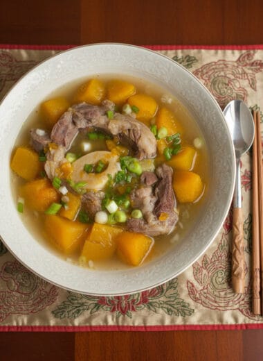 Bowl of Pumpkin Beef Shank Soup with tender beef, pumpkin cubes, and green onions on top, served with steamed rice