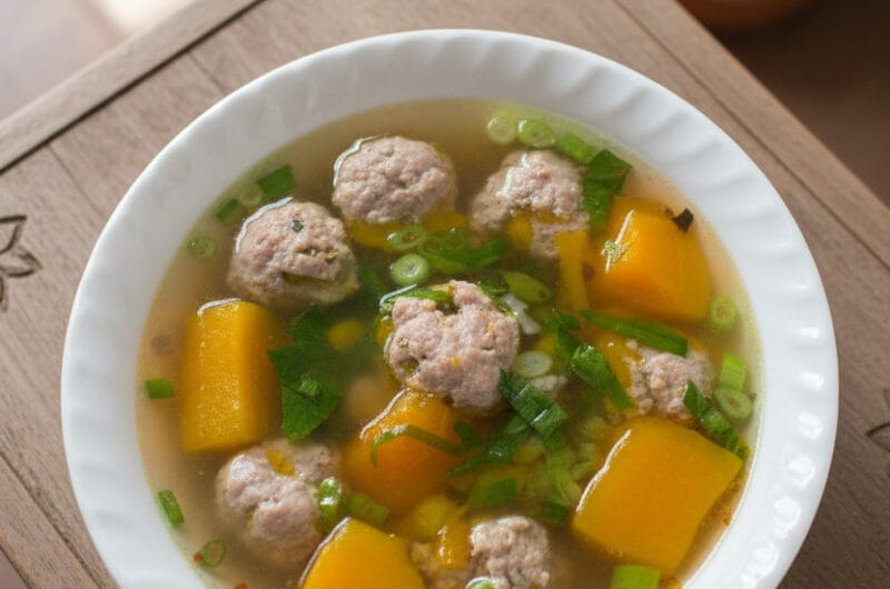 Bowl of Pumpkin and Pork Meat Balls Soup on a wooden table with Khmer-style decorations