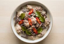 Bowl of Cambodian banana flower soup with chicken, coconut milk, and lemongrass.