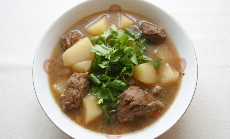 Overhead view of Beef and Potato Soup with tender beef, potato chunks, and fresh cilantro in a bowl.
