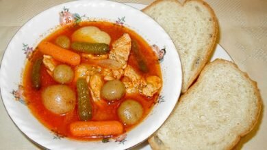 45-degree view of Khmer Krom chicken stew in a bowl with crusty bread on the side.