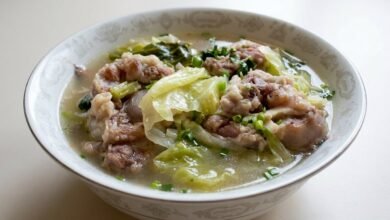 A bowl of Cambodian oxtail cabbage soup with tender oxtail, soft cabbage, and fresh green onion and cilantro.