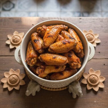 Bowl of baked Cambodian chicken wings with glossy honey glaze