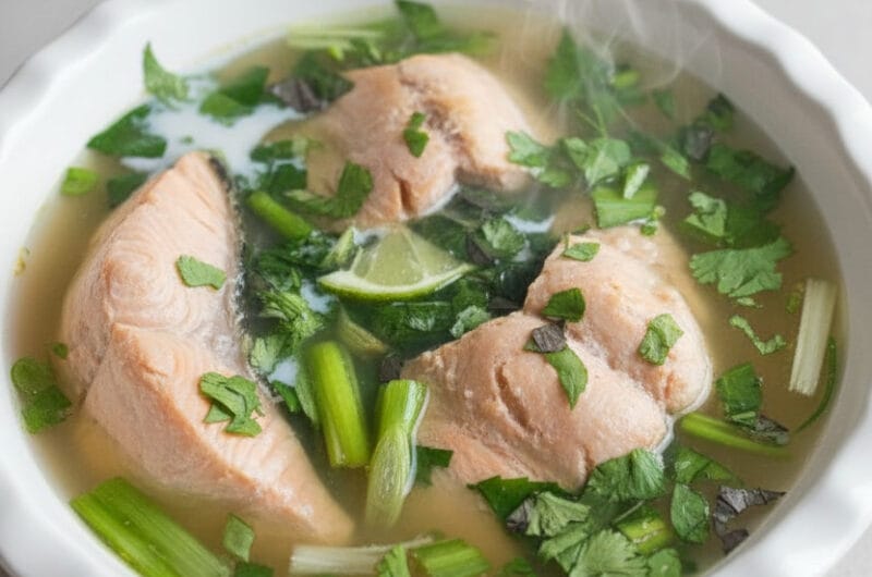 Cambodian salmon lime soup with fresh herbs served in a bowl