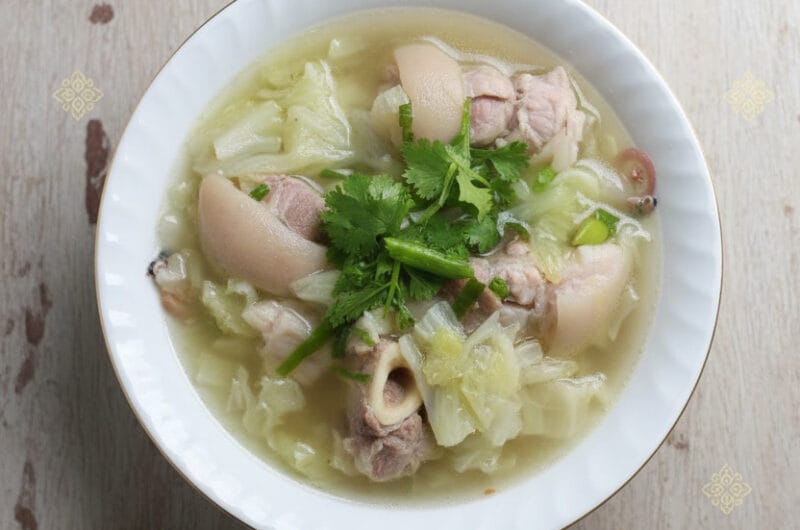 Centered bowl of pork hocks and cabbage soup in Khmer kitchen