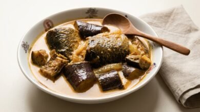 A bowl of Cambodian fish curry with chunks of trout and Asian eggplant in a creamy coconut sauce.