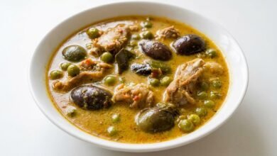 Overhead view of Cambodian curry pork riblets with eggplant in a golden coconut broth.
