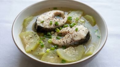 A bowl of Cambodian opo squash and fish soup with green onion and black pepper.