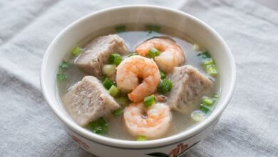 A bowl of Cambodian shrimp and taro root soup with tender taro chunks, pink shrimp, and chopped green onion in a light broth.