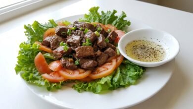 Cambodian beef loc lac with seared beef cubes, Romaine lettuce, sliced tomato, and lime-pepper sauce.