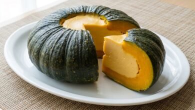 A whole steamed pumpkin filled with smooth coconut custard, photographed from above on a serving plate.