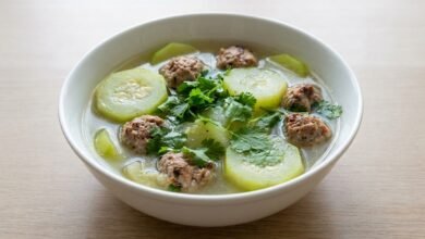 Overhead view of a bowl of Cambodian zucchini soup with pork meatballs and cilantro.