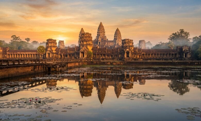 Angkor Wat temple complex at sunrise, with its five towers reflected in the moat