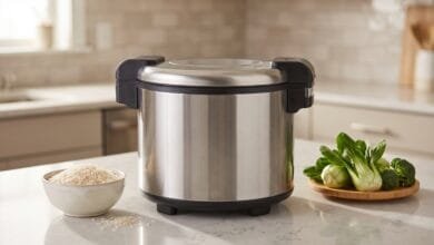 Aroma ARC-743 rice cooker on a home kitchen counter with a bowl of uncooked rice and fresh vegetables nearby