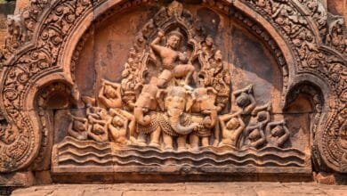 Intricately carved pink sandstone pediment at Banteay Srei temple in Cambodia