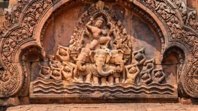 Intricately carved pink sandstone pediment at Banteay Srei temple in Cambodia