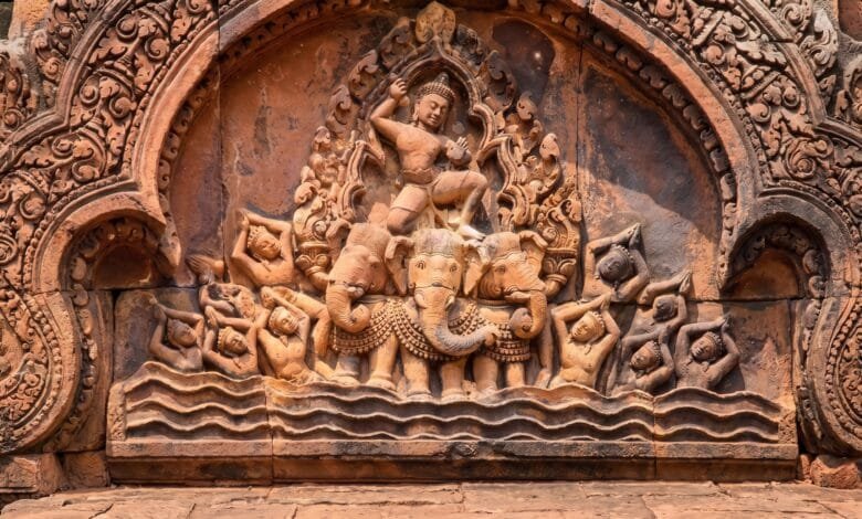 Intricately carved pink sandstone pediment at Banteay Srei temple in Cambodia