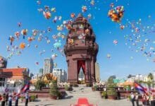 Crowds gather around the Independence Monument in Phnom Penh during the Cambodia Independence Day ceremony on November 9, with the Cambodian flag flying overhead.