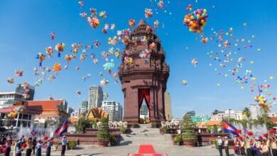 Crowds gather around the Independence Monument in Phnom Penh during the Cambodia Independence Day ceremony on November 9, with the Cambodian flag flying overhead.