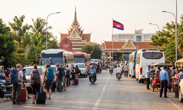 Travelers with luggage waiting near an immigration checkpoint at a Cambodia land border crossing