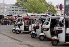 tuk-tuk parking near a busy market in Phnom Penh, Cambodia