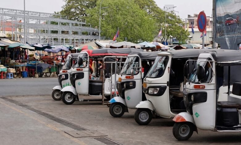 tuk-tuk parking near a busy market in Phnom Penh, Cambodia
