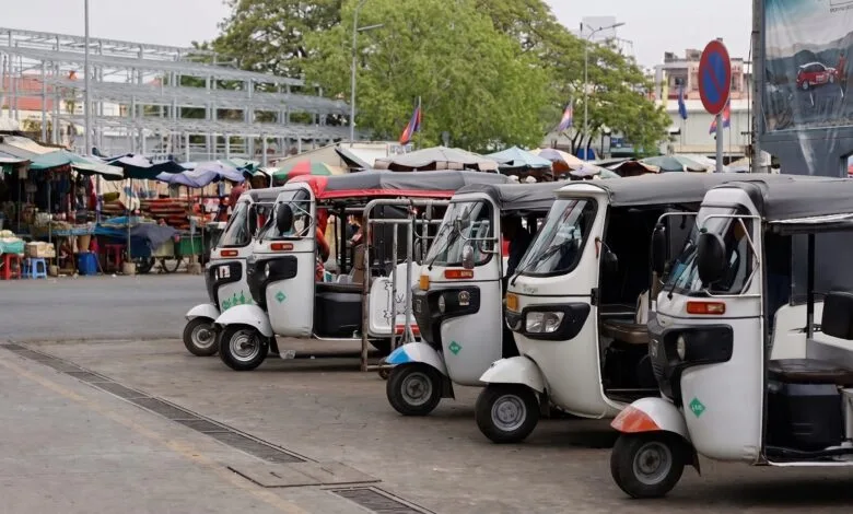 tuk-tuk parking near a busy market in Phnom Penh, Cambodia