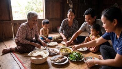 Cambodian family of three generations sharing a traditional meal with a central bowl of rice at a wooden dining table