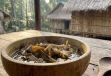 Dark chanang soup in a bamboo bowl with beef and herbs in Ratanakiri, Cambodia