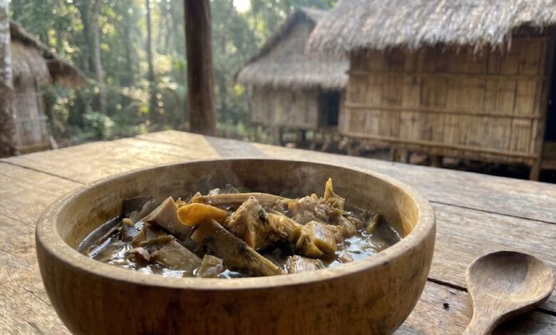 Dark chanang soup in a bamboo bowl with beef and herbs in Ratanakiri, Cambodia