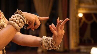 Close-up of a Khmer classical dancer's hands performing a kbach gesture with fingers bent backward