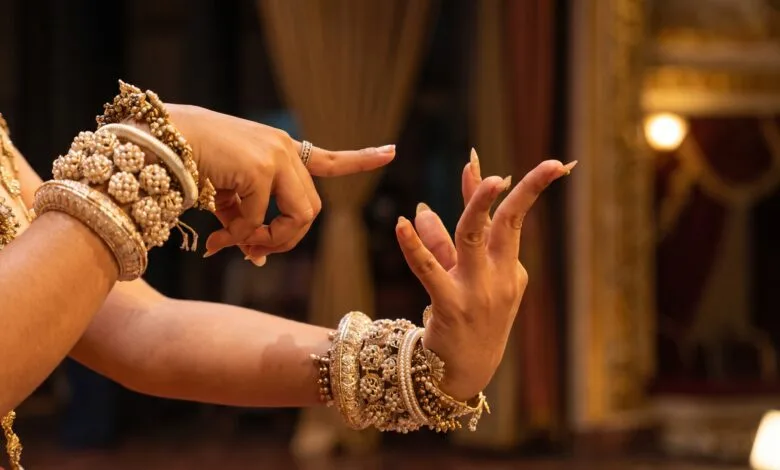 Close-up of a Khmer classical dancer's hands performing a kbach gesture with fingers bent backward