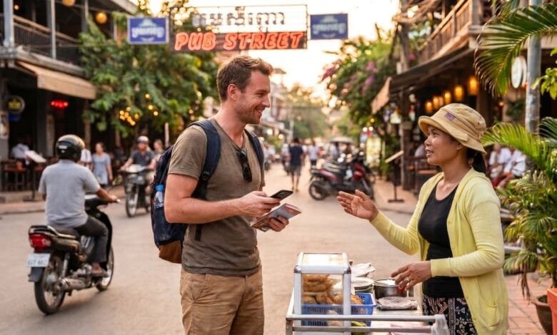 A foreign traveler smiles while talking with a Cambodian vendor at a street food stall in Siem Reap, holding a phrasebook.