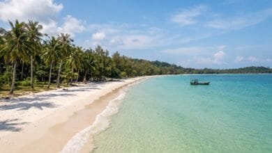 White sand beach with palm trees and clear tropical water on Koh Rong island in Cambodia