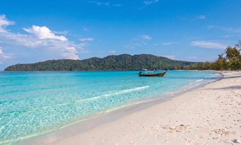 Saracen Bay on Koh Rong Sanloem, Cambodia, showing a curved white sand beach with calm turquoise water and jungle-covered hills