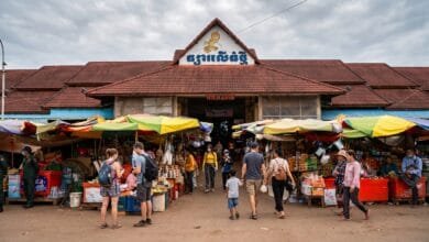 The yellow-and-white exterior of Phsar Leu Thom Tmey market building on National Road 6 in Siem Reap, Cambodia