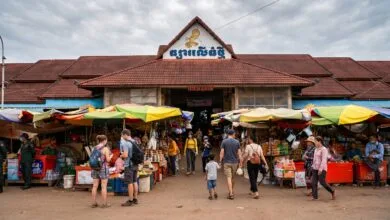The yellow-and-white exterior of Phsar Leu Thom Tmey market building on National Road 6 in Siem Reap, Cambodia