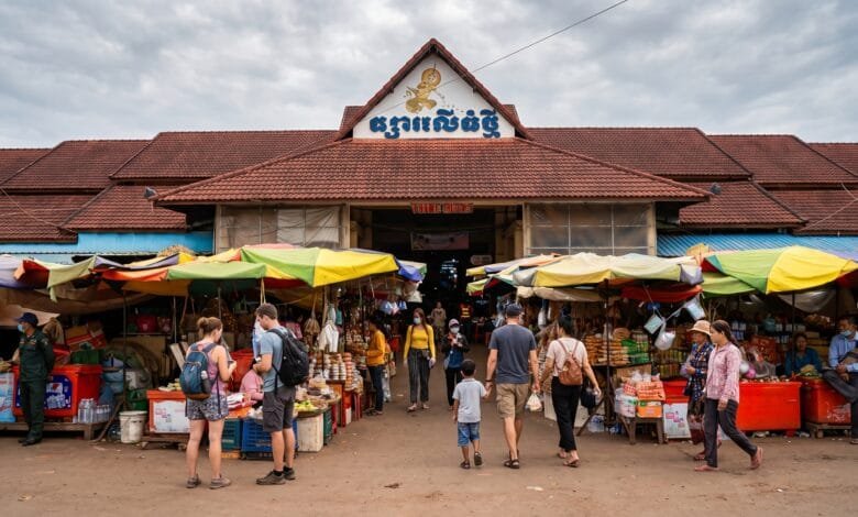 The yellow-and-white exterior of Phsar Leu Thom Tmey market building on National Road 6 in Siem Reap, Cambodia