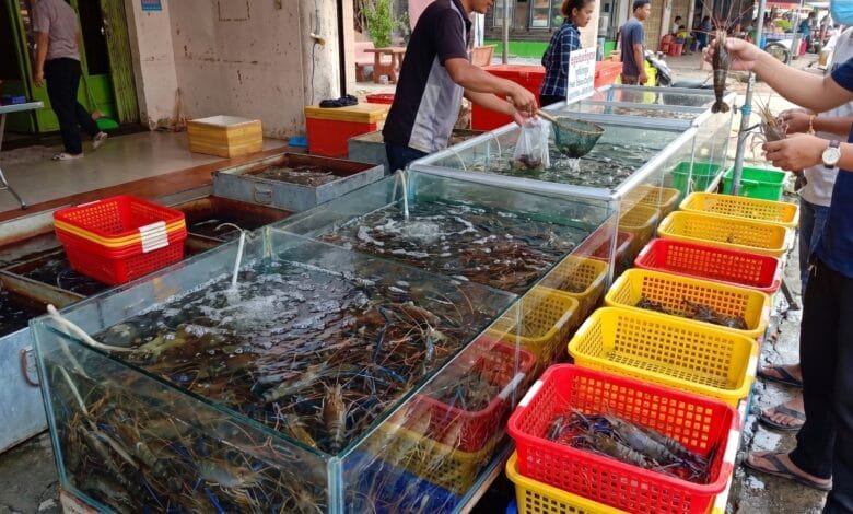 Fresh Takeo crayfish displayed on a wooden platter at a morning market in Takeo province, Cambodia