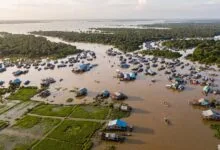 Aerial view of the expanded Tonle Sap Lake in Cambodia during the wet season, with flooded forests and stilted houses.