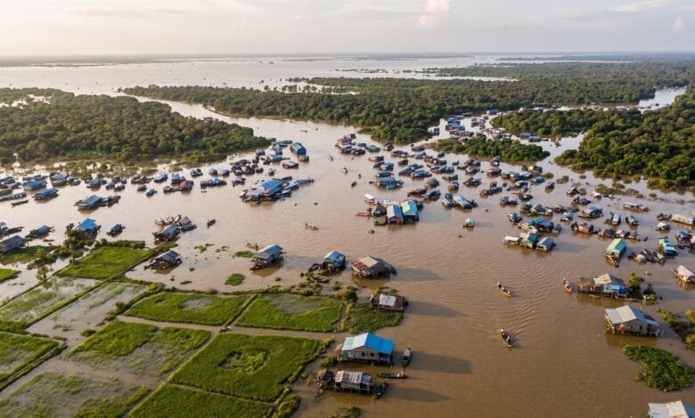 Aerial view of the expanded Tonle Sap Lake in Cambodia during the wet season, with flooded forests and stilted houses.