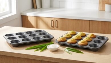 Amazon Basics nonstick muffin pan set of 2 with 12 cups each, shown on a kitchen counter with baked muffins and pandan leaves.