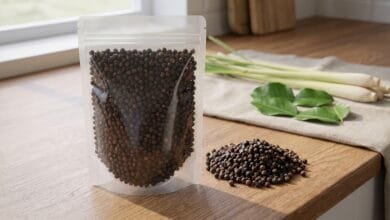 Bag of organic black Kampot peppercorns from Cambodia, 8 ounce size, with whole dried peppercorns visible.