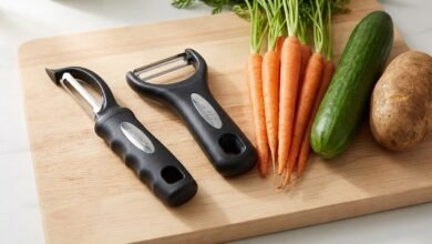 Spring Chef swivel peeler and Y peeler set on a wooden cutting board with fresh carrots, cucumber, and potato