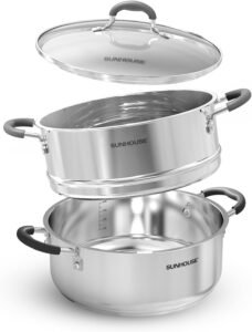 stainless steel steamer pot on a stovetop with vegetables and dumplings in the steamer basket